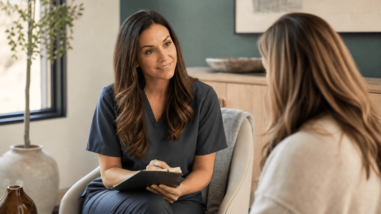 A provider seated in unhurried conversation with a client during a consultation